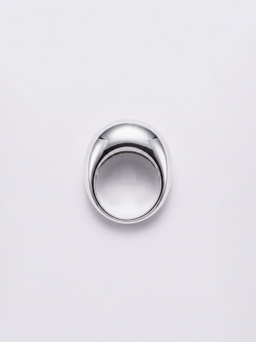 A polished silver dome ring with a smooth, reflective finish, centered on a light gray background.