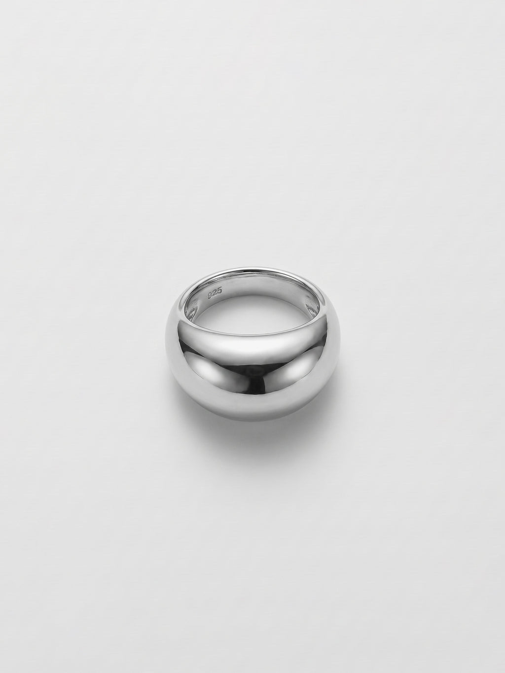 A polished silver dome ring with a smooth, rounded profile, photographed on a clean light gray background.