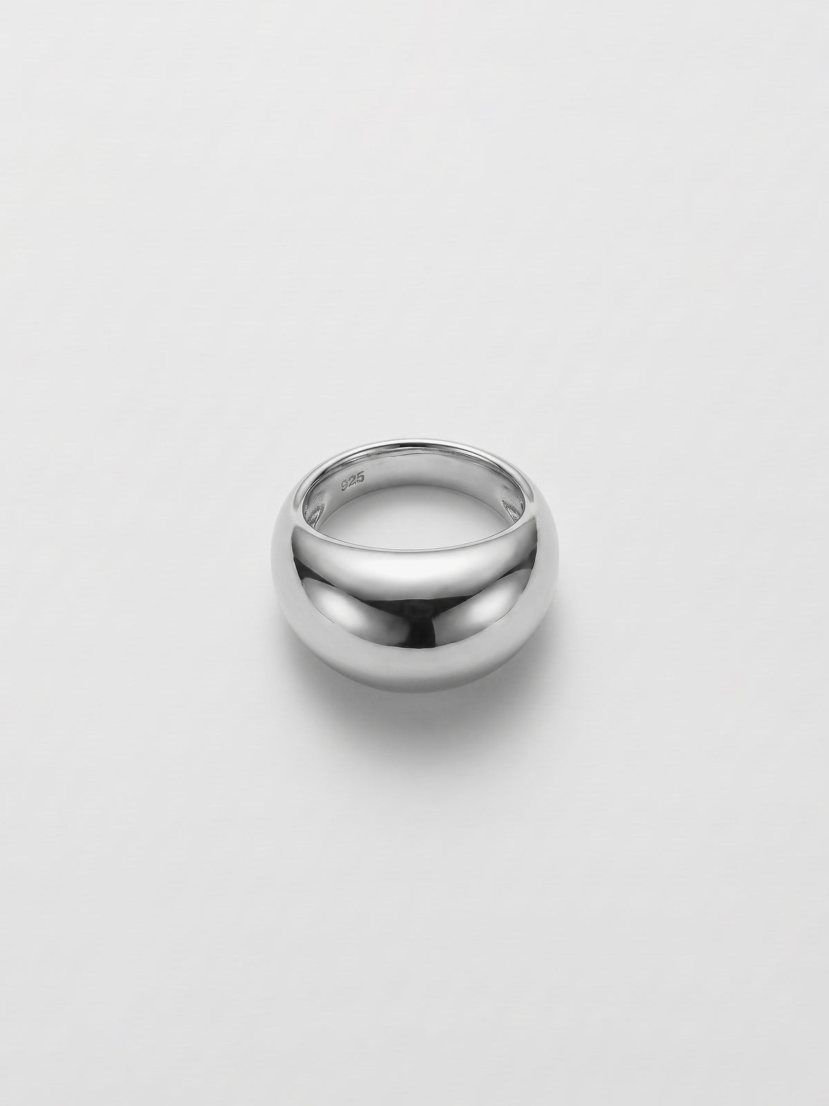 A polished silver dome ring with a smooth, rounded profile, photographed on a clean light gray background.