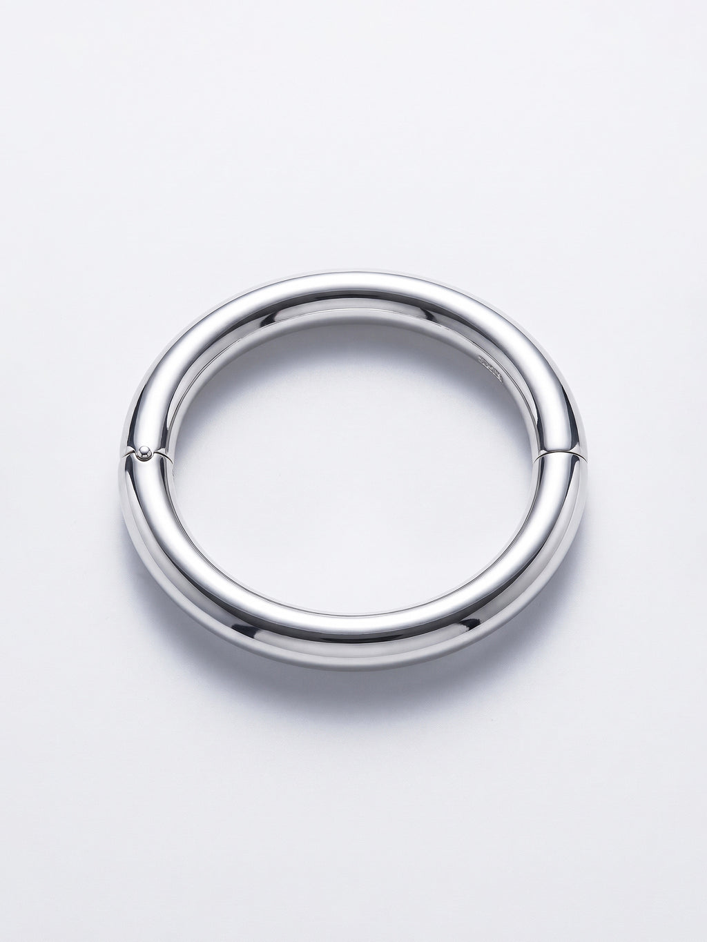 A polished silver ellipse bangle with a small hinge on one side, shown on a clean white background.