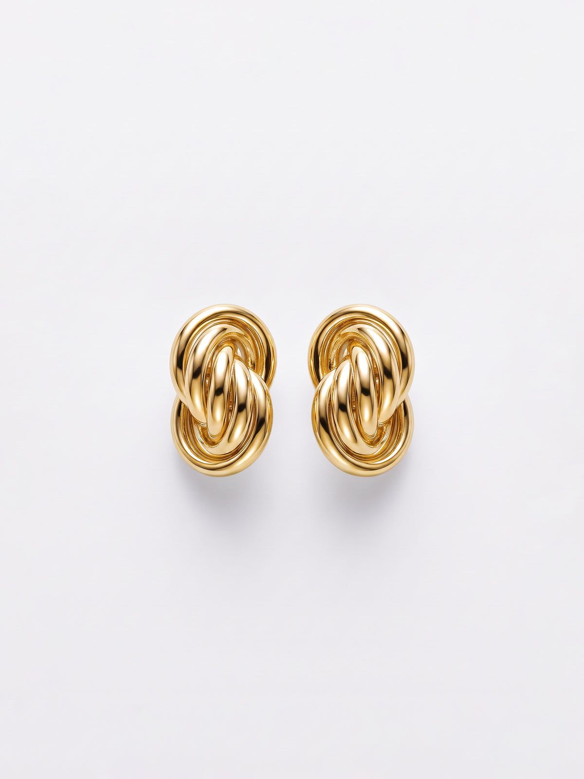 A pair of gold-toned knot stud earrings with a polished, interlocking design, displayed on a clean white background.