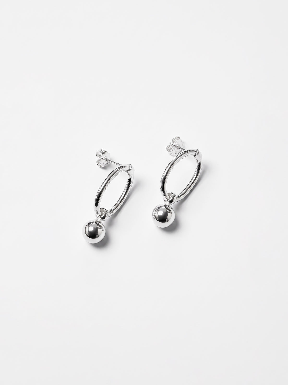 Pair of silver drop orbit shape earrings on a white background 