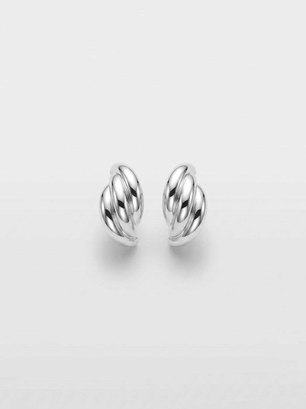 A pair of polished silver stud  earrings with a twisted, wing-like design, shown on a clean light gray background.