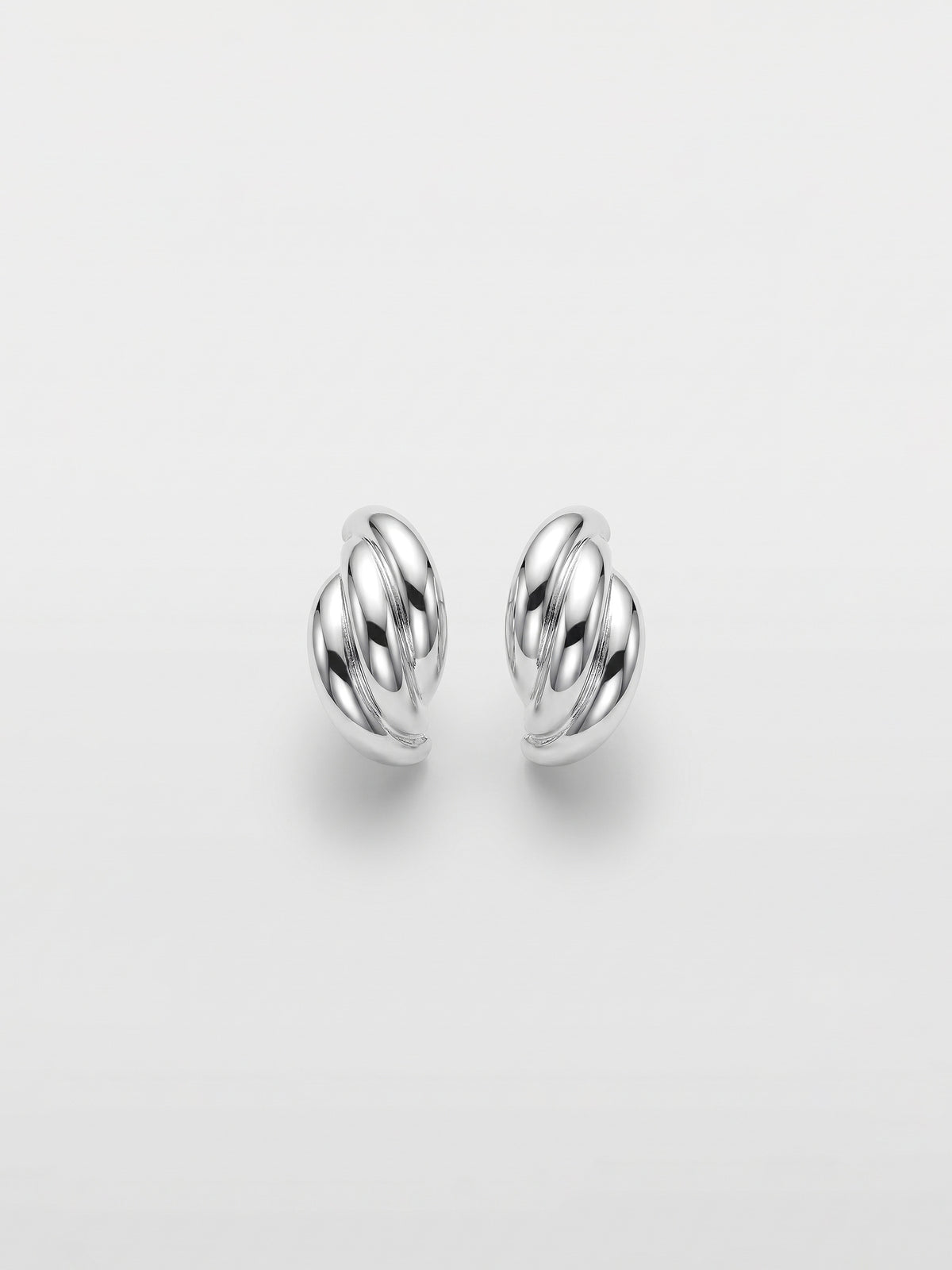A pair of polished silver stud  earrings with a twisted, wing-like design, shown on a clean light gray background.